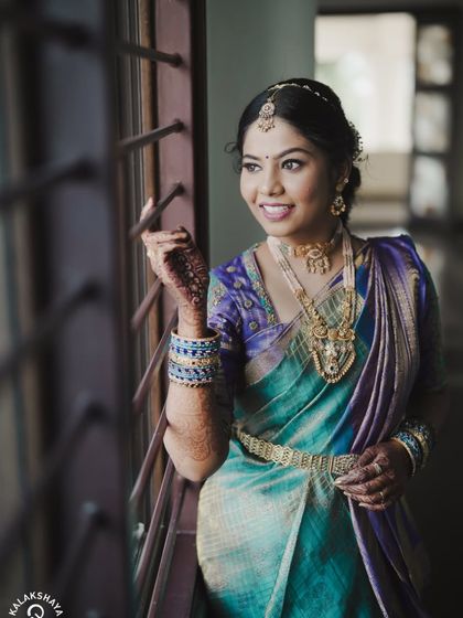 A happy bride looking out a window, her face full of light and joy.