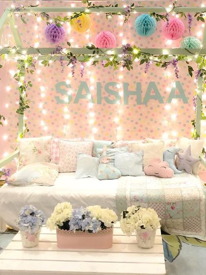 A cozy and dreamy bedroom setup for a pajama party. The bed frame was decorated with fairy lights and vines, creating a magical space for the birthday girl.