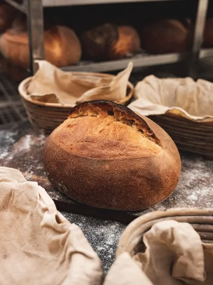 A perfectly baked loaf of our artisanal sourdough bread, fresh from the oven and ready to be cooled.