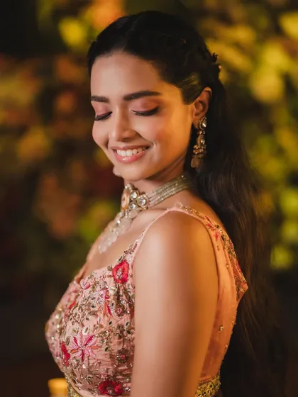 A close-up of the joyful, smiling bride. The pink-toned eye makeup adds a touch of playfulness.