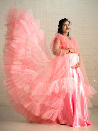 The fan-like trail of this pink maternity gown creates a stunning visual effect. It's a perfect example of the dramatic flying gowns I have available for rent.