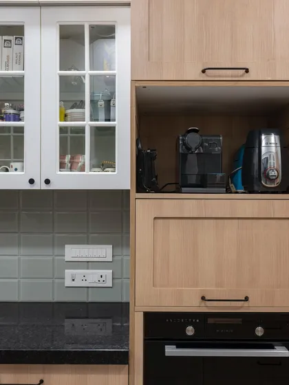 An appliance garage and glass-fronted cabinets sit side-by-side, offering both concealed and display storage. The mix of open and closed spaces keeps the kitchen functional and visually interesting.
