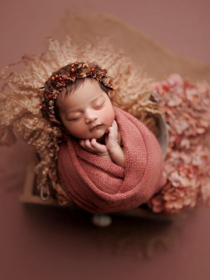 The rich, rosy tones of the wrap and flowers create a warm and romantic feel for this portrait. The tiny berry crown adds a perfect, delicate touch.