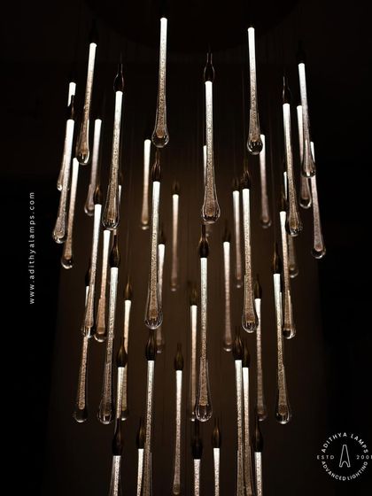 A stunning cluster of crystal teardrop pendants. Each pendant contains bubble-like inclusions that catch the light, creating a sparkling, rain-like effect. This is an elegant choice for double-height foyers or modern staircases.
