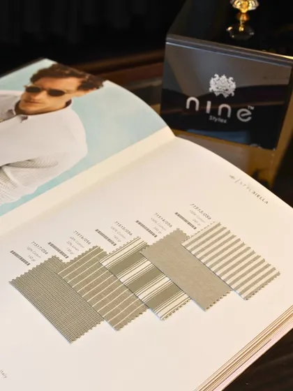 A client browsing a fabric catalog in our store. The process of selecting the right material is a key part of our bespoke gifting service.