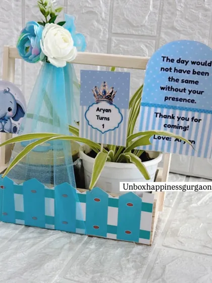 This blue elephant-themed basket is a perfect return gift for a little boy's first birthday party, complete with custom tags and decorations.