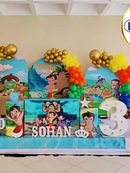 A vibrant Chhota Bheem-themed third birthday party. This setup features multiple backdrops with scenes from the show, character cutouts, and colorful balloon columns.