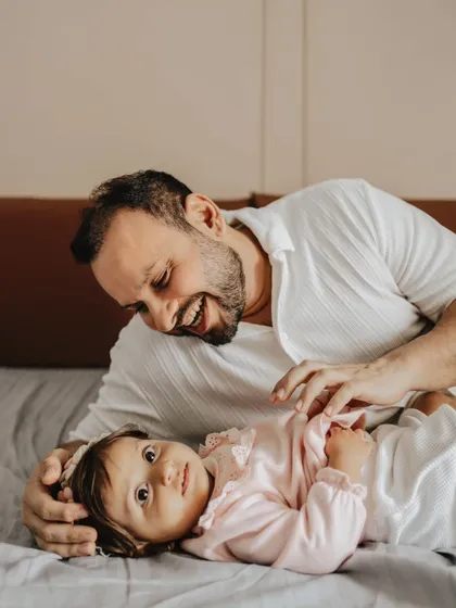 A playful moment between a father and his daughter. In-home lifestyle sessions are perfect for capturing your family in your most comfortable environment.