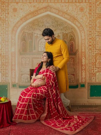 A loving couple posing against a majestic, palace-inspired backdrop. This traditional maternity shoot has a regal and timeless quality.