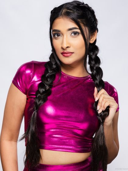 A confident portrait of the model in the metallic pink outfit.