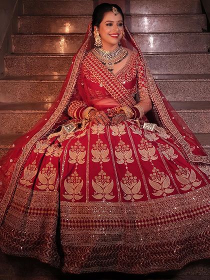 The smile of a happy bride says it all. This look features a classic bridal updo, subtle contouring, and a radiant complexion that glows with happiness, perfect for a traditional Hindu wedding.