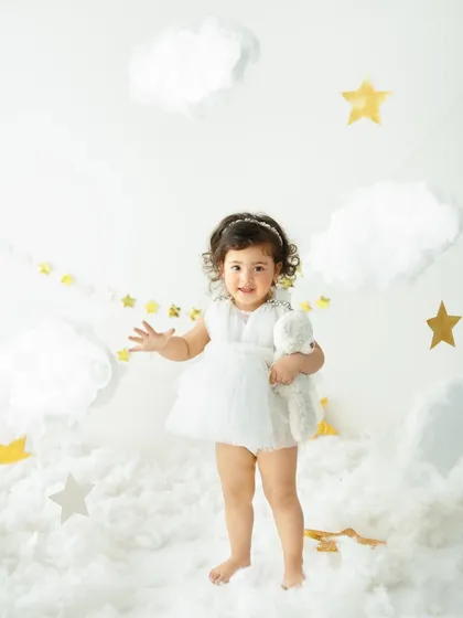 For those who dream a little bigger, I create magical themed sessions. This 'Dreamland Under the Stars' setup transforms my studio into a celestial fairytale, with fluffy clouds and golden stars, making your little one the star of their own story.