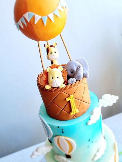 A close-up of the hot air balloon topper, with a lion, giraffe, and elephant inside.