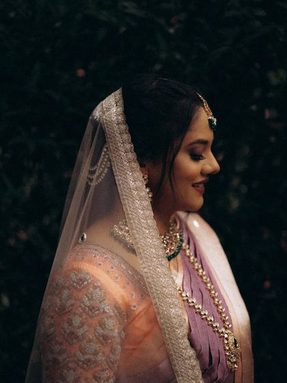 A close-up profile of the bride, with her veil creating a soft frame. This highlights her serene expression and the delicate details of her look.
