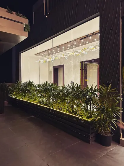 We used long, custom-built planters to line the glass facade of this building. The planters are filled with lush greenery and feature integrated strip lighting at the base, adding a touch of modern elegance and defining the outdoor walkway at night.