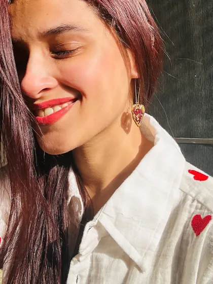 A sun-kissed photo of me wearing the heart-shaped rose petal earrings. They are so lightweight and lovely.