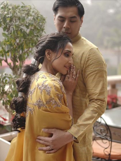 A romantic moment between the bride and groom during the Haldi ceremony. Her makeup is soft and natural, enhancing her joyful expression.