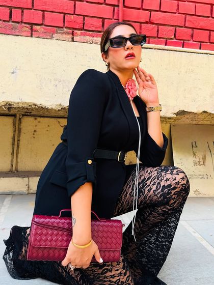 A powerful pose in a powerful outfit. The combination of a structured blazer and delicate lace pants creates a beautiful play of textures, making this a standout look for any event.