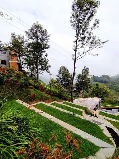 The terraced landscape and water channels at VAY, Hulical. This system is not just for aesthetics; it's a functional design for managing rainwater on a steep slope, guiding it through public spaces and preventing erosion.