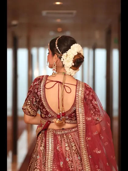 The back view of this maroon bridal lehenga showcases the detailed embroidery and the beautiful fall of the dupatta, perfect for capturing stunning photos.