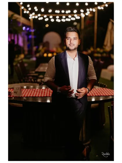 The groom looking dapper and relaxed. His bespoke waistcoat, paired with a simple shirt, is the perfect choice for a smart-casual intimate dinner.