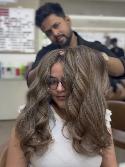 A stunning ash brown hair color transformation. The client looks beautiful and confident with her new cool-toned waves.