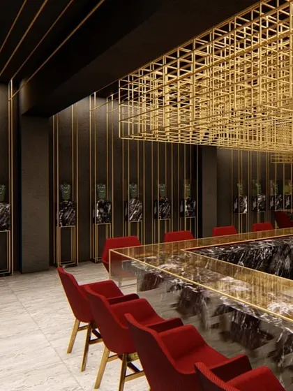 A view into a high-end jewelry showroom in Lucknow, designed to feel like a precious box. We used a suspended brass mesh structure to define the space and act as a lighting fixture, creating a dramatic contrast with the dark, coarse walls and polished marble counters.