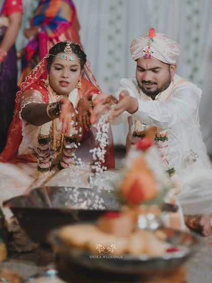The couple performing a fire ritual together, a central part of their traditional Hindu wedding ceremony.
