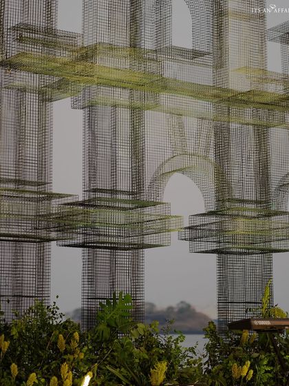 An artistic shot of the complex mesh structures, designed to look like architectural sketches against the sky, adding an industrial-chic element.
