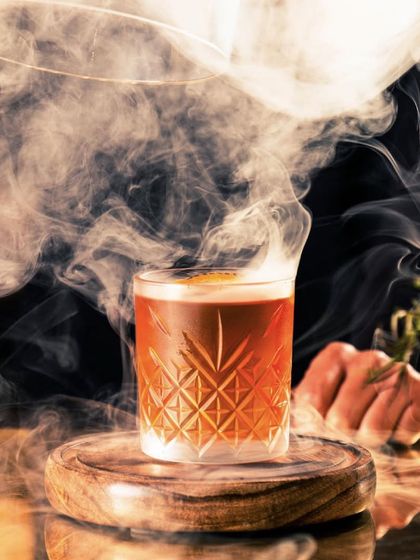Let our cocktails be your passport to a realm of culinary delight. This smoky, classic cocktail, served over a large ice cube, is where mixology takes center stage and flavor reigns supreme.
