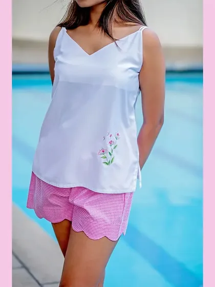 To show the versatility of the collection, we did a poolside shoot. This image of a white camisole and pink gingham shorts shows that the brand's pieces are perfect for lounging by the water, not just for sleeping.