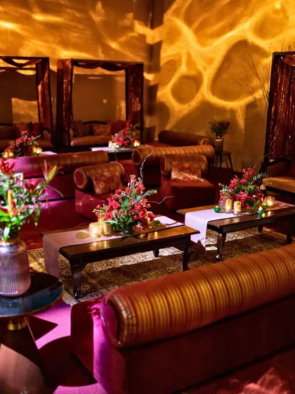 Creating intimate lounge spaces is key to a good party. This cozy seating area features rich, jewel-toned velvets and warm, patterned lighting, offering guests a comfortable spot to relax and socialize.