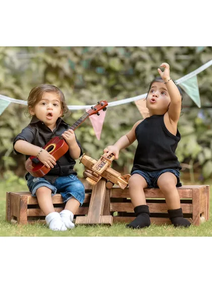 A pre-birthday jam session for these adorable twins. Using props like a ukulele and a wooden airplane, we created a playful scene that shows off their budding personalities and the fun we have during our outdoor shoots.