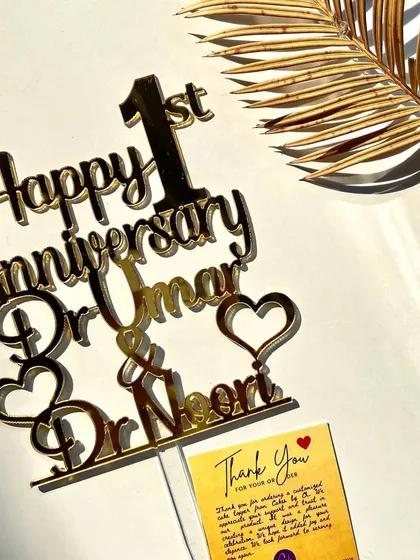 The "Happy 1st Anniversary" topper for the doctor couple, elegantly styled with a thank you card.