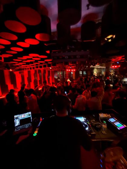 The view from my console at a packed club, with red lights creating an intense, underground vibe.