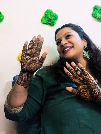 Another happy client moment. Her joy is evident as she admires her beautiful henna design.