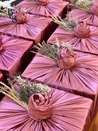 The art of fabric wrapping shown up close. This image highlights the beautiful texture of the pleated dusty rose satin, the intricate rose knot, and the delicate dried lavender sprigs that complete this elegant look.