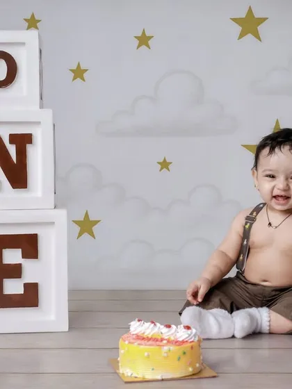 A simple and sweet cake smash session with a starry background. This setup is perfect for keeping the focus on your child's happy and curious expressions as they approach their first cake.