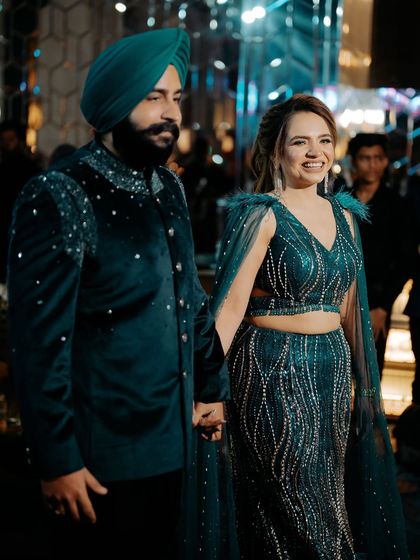 A happy couple making their grand entrance. Her smile and glowing makeup light up the frame.