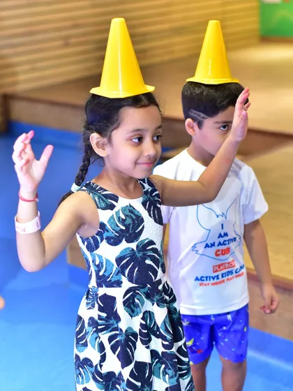 Getting silly with cone hats during a camp game. I believe in making learning fun, and even simple props can spark imagination and lead to lots of giggles and creative play.