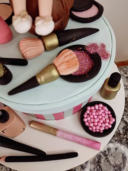 A close-up of the little girl's makeup cake, showing the glittery eyeshadow and pink pearl sprinkles.