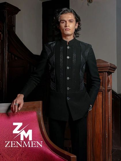 A model wearing a black velvet bandhgala with tonal leather-like detailing. This is a sleek, modern take on a classic silhouette, perfect for a reception.