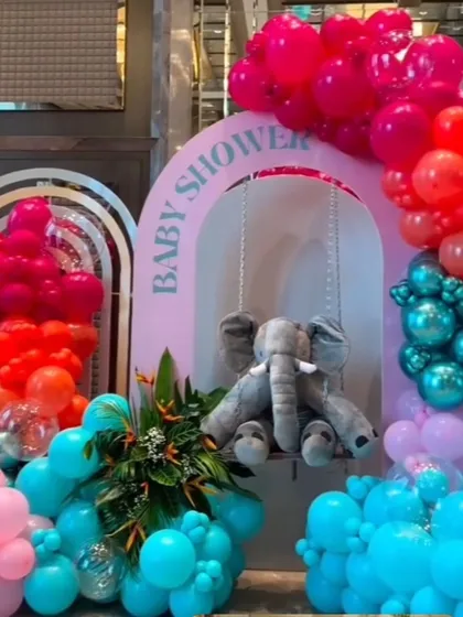 The main backdrop for the elephant baby shower, featuring a plush elephant on a swing under a "Baby Shower" arch.