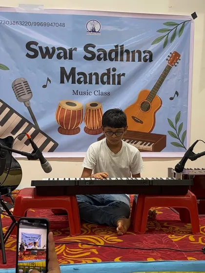 A student performs on his keyboard, with his proud parent capturing the moment. We love seeing families support our young musicians on their journey.