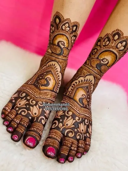 Don't forget your feet! This bridal foot mehandi features bold peacock motifs, a popular choice for brides, framed by delicate floral patterns. I ensure the design is symmetrical and beautifully adorns the feet, completing your head-to-toe bridal look.