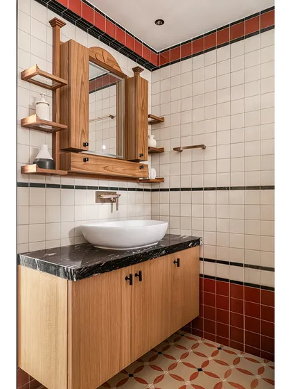 This bathroom from our Kolam Pop project uses a simple palette of white, terracotta, and black tiles to create a strong graphic rhythm. The custom teak vanity and mirror cabinet, with its asymmetrical shelves, adds a layer of handcrafted warmth.