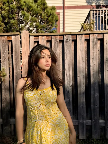 A wind-swept moment in the yellow Jardinvue dress, adding a dynamic and natural feel.