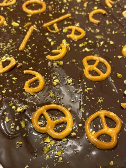 Creating a batch of my sweet and salty chocolate pretzel bark. The combination of rich dark chocolate, crunchy pretzels, and a sprinkle of pistachio is incredibly addictive.