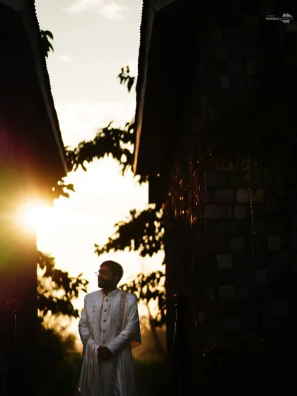 I believe in the power of dramatic lighting to create unforgettable portraits. This silhouette of the groom against the golden hour sun is a perfect example of how I use light to craft artistic and soulful images.