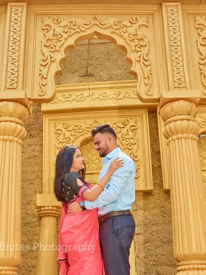 A sweet, candid moment captured against the detailed facade of our sandstone-colored palace set, perfect for a save-the-date photo.